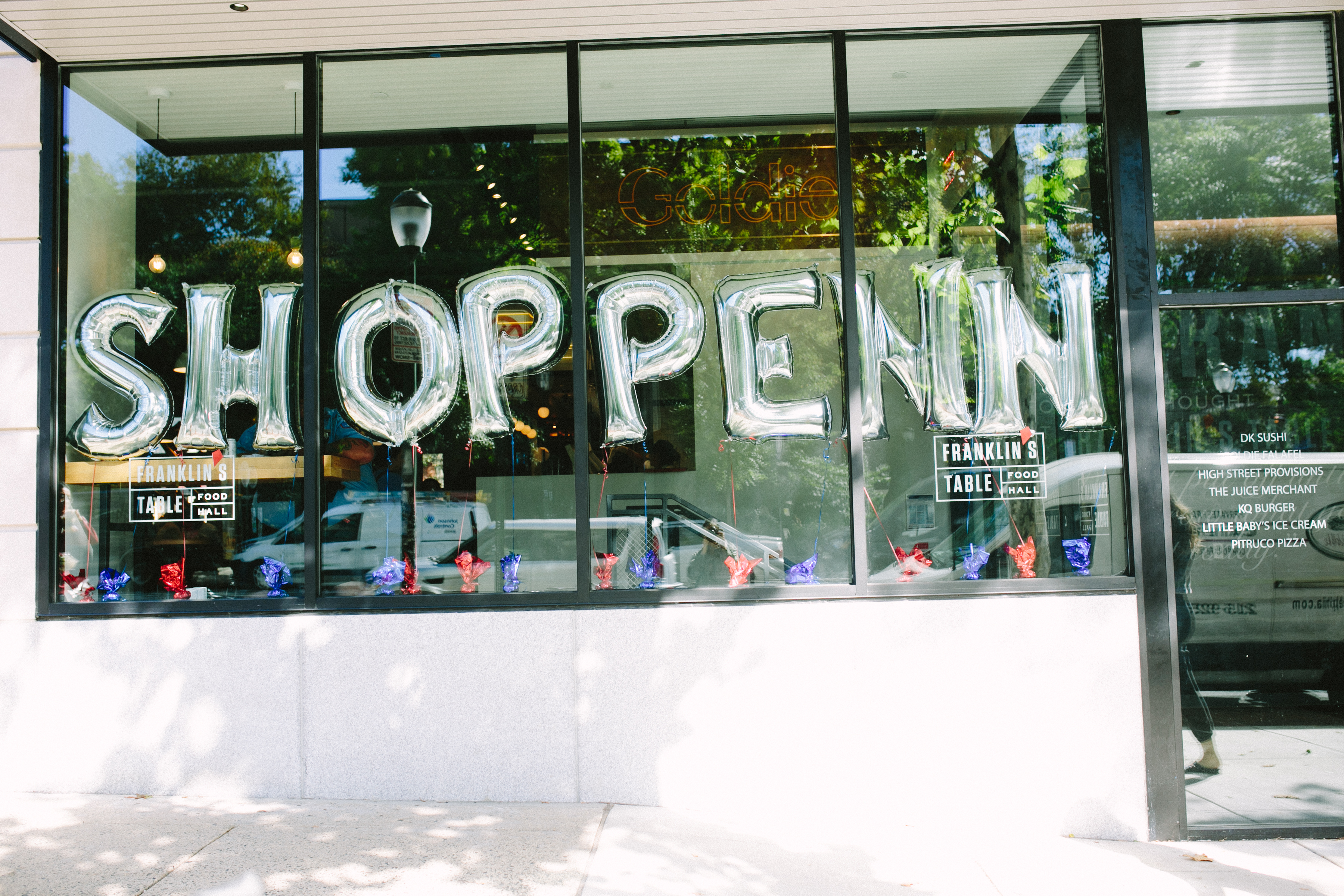 balloons in a window spelling out shop penn