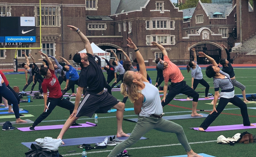 group doing yoga on football field