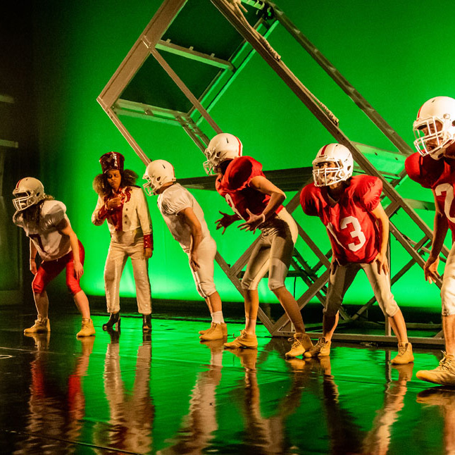 dancers dressed as football players on stage