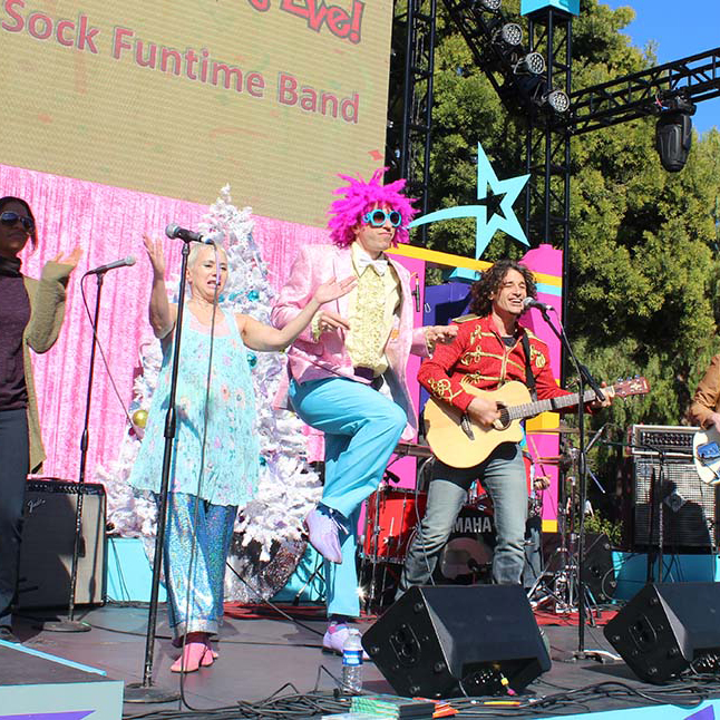 May Playlist 25 band in costumes performing on outdoor stage