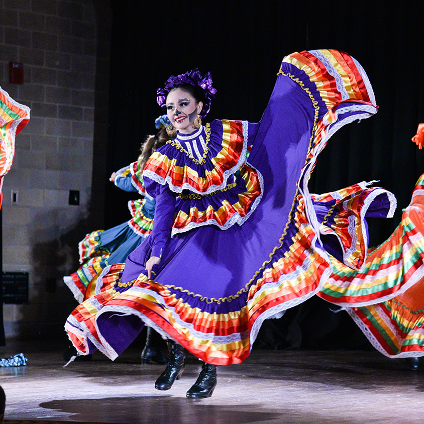 dia de los muertos dancers performing in makeup and costumes