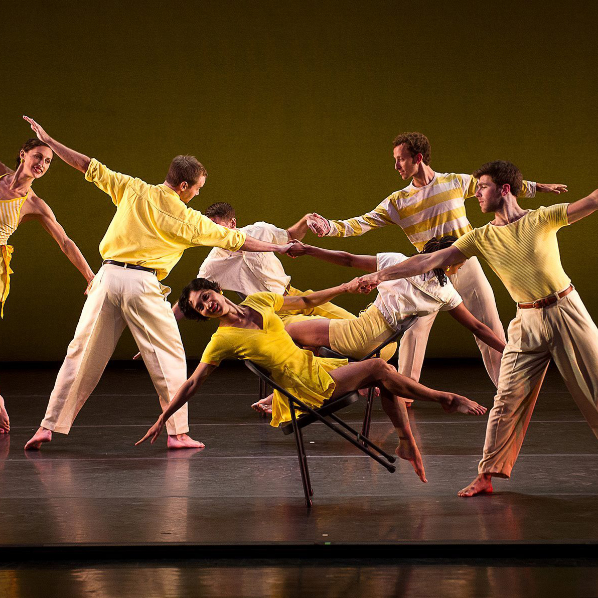 dancers performing in yellow outfits on a stage