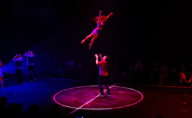 woman in the air with man underneath to catch her