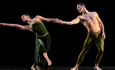 two dancers on stage in front of a black background