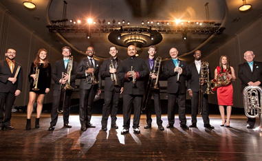 brass band lined up on stage holding their instruments