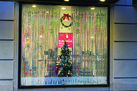 holiday window decorated with streamers and a tree