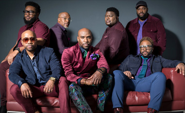 seven black men posing on a couch