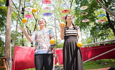 male and female jugglers performing outside