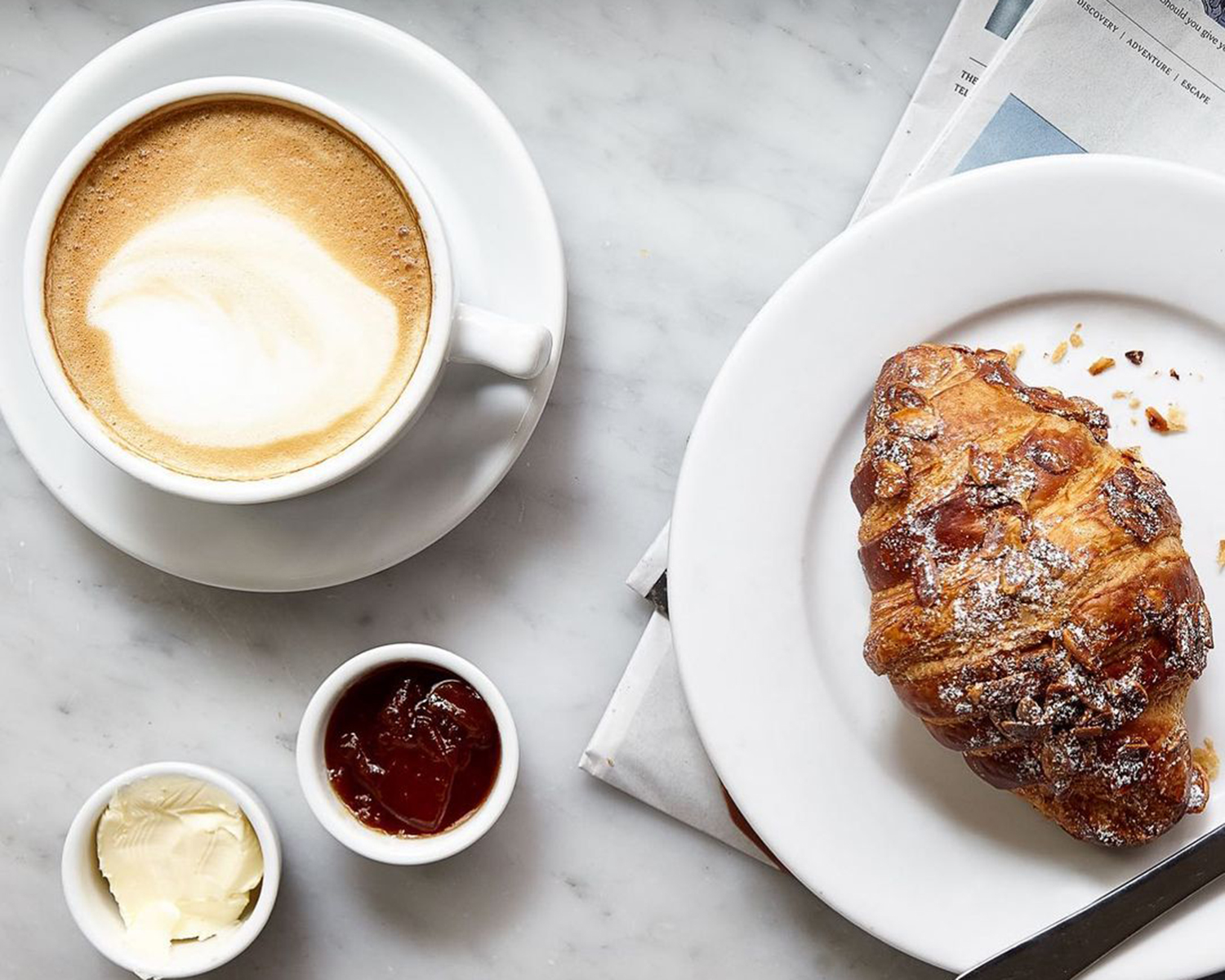 espresson and a croissant on a marble table
