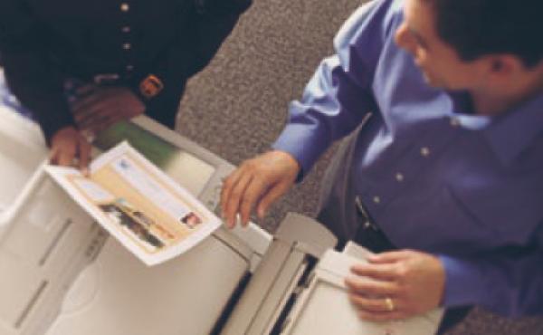 Two individuals making copies inside the UPS Store.