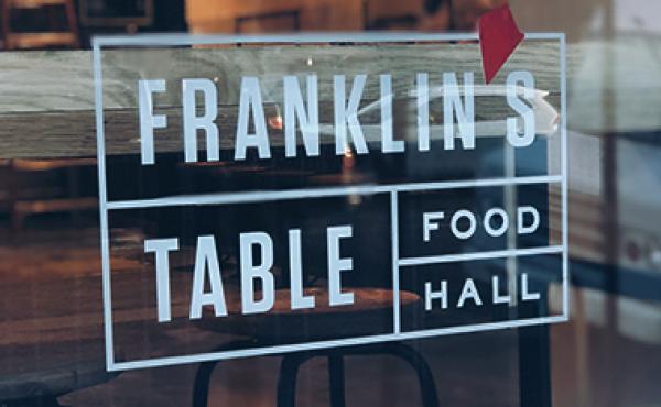 Photo of Franklin's Table logo on food hall window