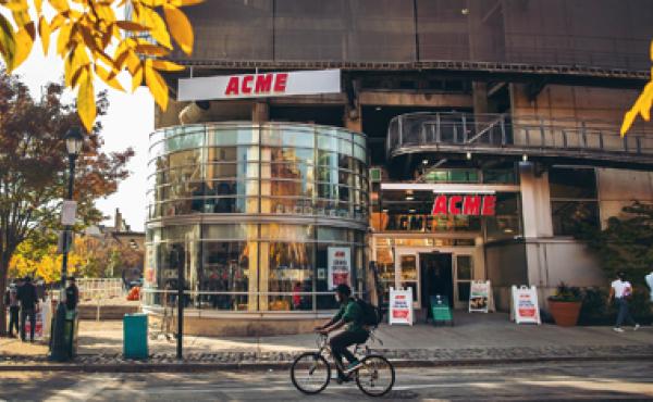 acme storefront with man on bike in front