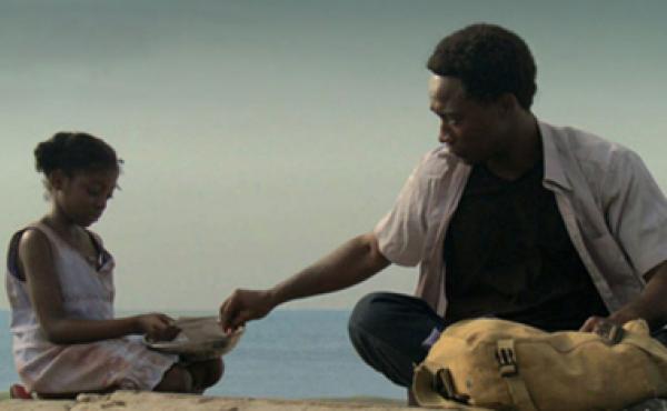 black man and girl sitting on the ground together
