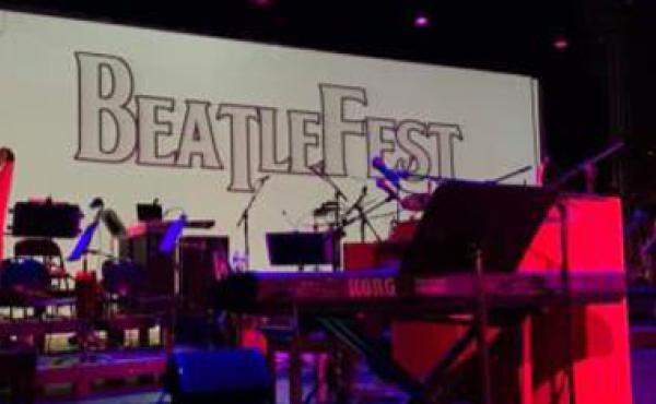 instruments on stage with screen saying beatles behind