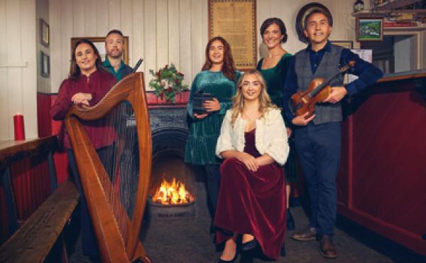 musicians in festive clothes posing in a cozy room