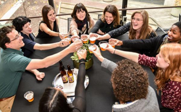 people around a table cheersing their drinks