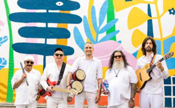 men in white shirts and shorts with instruments in front of colorful wall