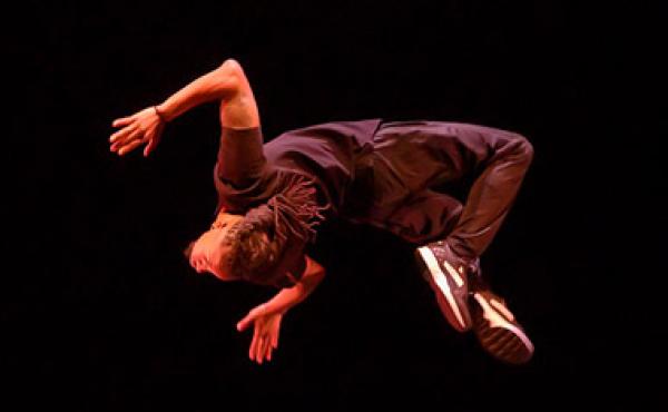 man doing backflip in front of black background