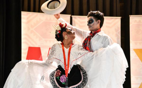 two dancers in mexican costumes with faces painted