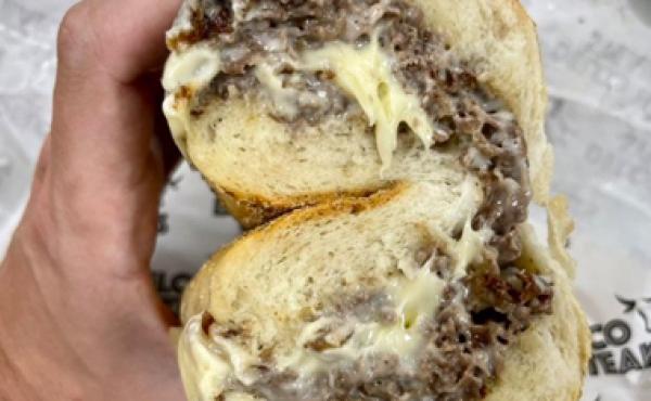 Hand holding a cheesesteak