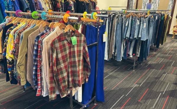 clothes hanging on several clothes racks