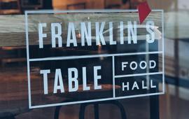 Photo of Franklin's Table logo on food hall window
