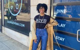 black woman posing in front of a shop door